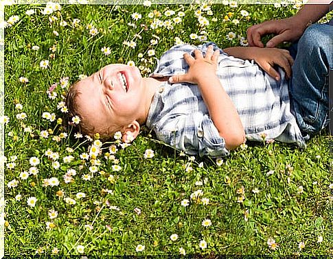 Child laughing at the tickling they make him symbolizing the phrases of Gianni Rodari