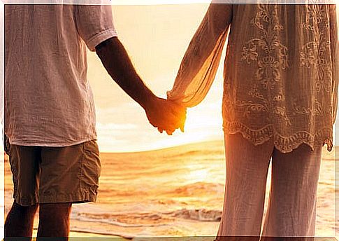 Couple holding hands on the beach