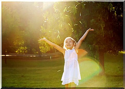 Happy girl in the field with open arms