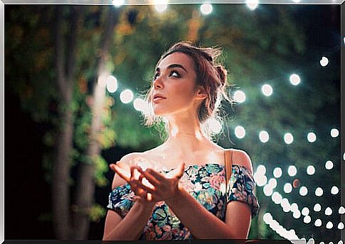 Woman walking through a natural place with lights thinking about the effect of consciousness and awareness