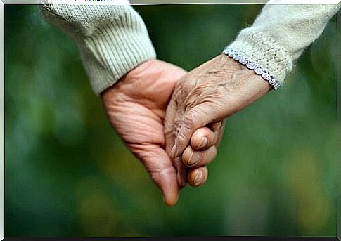 Elderly couple holding hands