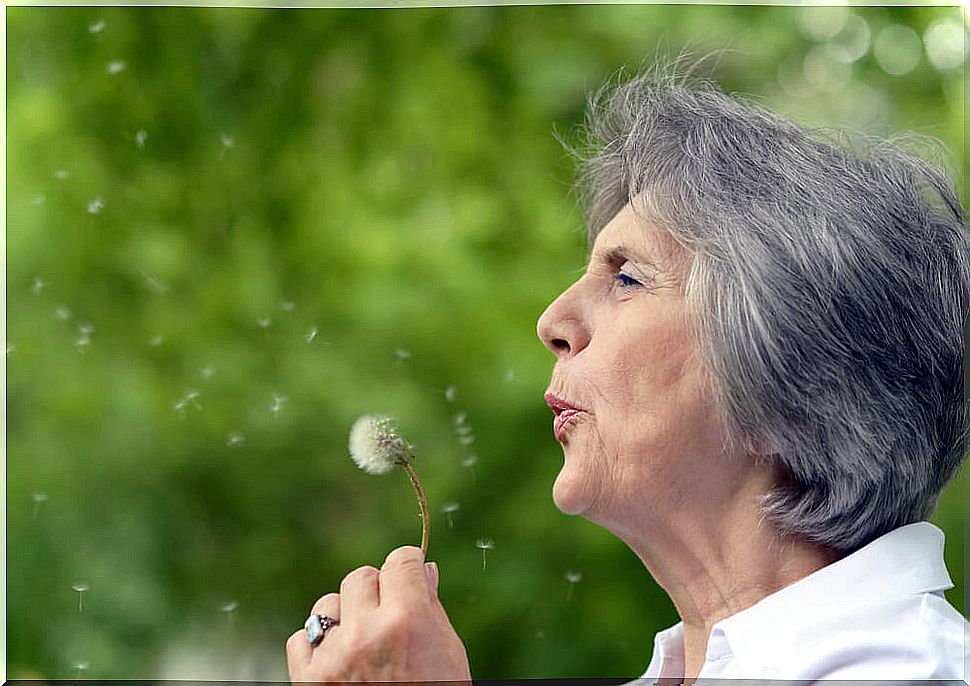 Woman blowing dandelion