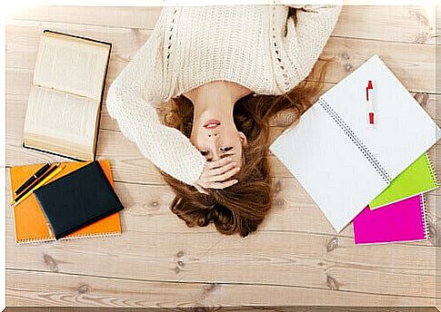 Stressed perfectionist woman lying on the floor to represent types of procrastination