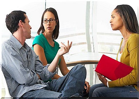 Man giving his opinion to his two female colleagues in a meeting