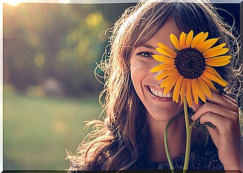 Woman with a sunflower smiling